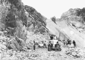 Gravemaskiner i arbeid ved et marmorbrudd i Apuan-alpene, Toscana. Noen av dem sitter på blokker med marmor som allerede er firkantet. (s/hvitt bilde)