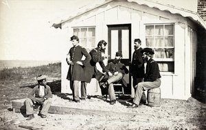 Fem borgerkrigssoldater samlet på veranda utenfor hjemmet, afroamerikansk ungdom satt i nærheten av dem, 1861-65 av American Photographer