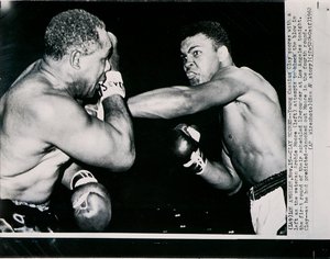 Unge Cassius Clay scorer med venstre mot veteranen Archie Moore i første runde av kampen i Los Angeles av American Photographer
