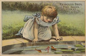 Ung jente ser på fisk i dammen av American School