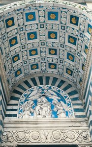 Sentralhvelv av portiko, med blå koffert og forgylte rosetter, og lunette over, med relieff av glasert lertøy av Madonna og barn av Andrea Della Robbia