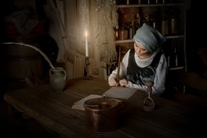Kvinne som skriver ved stearinlys av Andrzej Lisowski