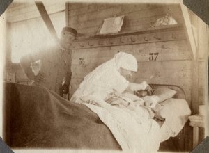 Første verdenskrig 1914-1918: sykepleier i bluse barberer en soldat (franske krigssår ligger i en seng), i Couville, Manche, Basse-Normandie (Nedre-Normandie), Frankrike. Anonymt fotografi juli 1917. Privat samling, Stella. av Anonymous Anonymous