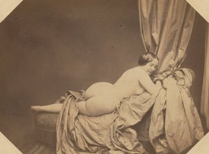 Akademisk naken, tilbakelent på en sofa av Auguste Belloc