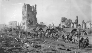 En uidentifisert australsk maskingeværseksjon med pakkede hester som passerer ruinene av kledehallen. Legg merke til flere motorvogner parkert i bakgrunnen, 19. oktober 1917 av Australian Photographer