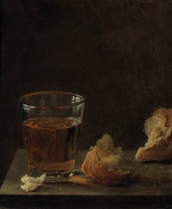 Et glass øl og en rundstykke på et bord
