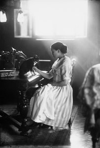 Portrett av Wanda som sitter ved et bord med katten sin, Trieste, ca. 1910 (glassplate)