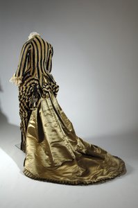 Aftenkjole, c.1884 (skrå utsikt bakover). Silkesateng og kuttet fløyel, blonder, silketråddusker og frynser. Charles Frederick Worth, Frankrike.