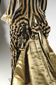 Aftenkjole, ca. 1884 (bakside skrå visning av travle detalj). Silkesateng og kuttet fløyel, blonder, silketråddusker og frynser. Charles Frederick Worth, Frankrike.