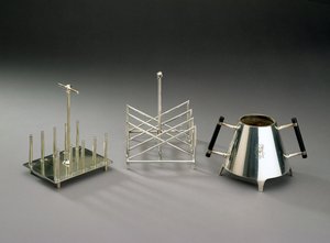 Toaststativ med stående støtter, produsert av Hukin & Heath, 1878 (se 46533 for detaljer); trekantede toaststativ, produsert av Elkington & Co., ca. 1875-88; sukkerskål med ebonisert tre h