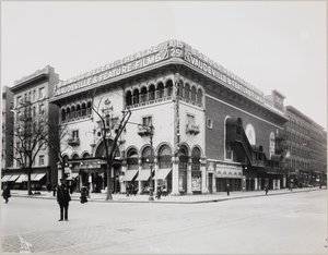 Et enormt teater med en forseggjort fasade, komplett med mauriske buer og balkonger. Et stort skilt på toppen av bygningen viser "BS Moss Regent Theatre Vaudeville & Feature Films." Et skilt som reklamerer for Olga Petrova i 'The Heart of