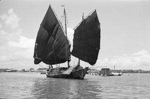 En klokkeformet havneskrot under seil i Singapore