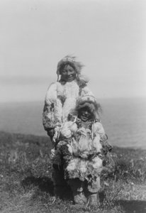 Et lite barn og en eldre eskimo iført parkas med andeskinn, Nunivak Island, Alaska, ca. 1929 (s/hvitt-bilde) av Edward Sheriff Curtis