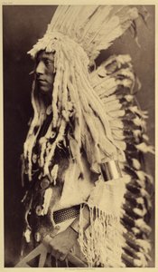 Gammel person, Piegan. Unge menn går ikke glipp av noen anledninger til offentlige festligheter for å ta på seg klærne til sin krigerfar. Foto hentet fra bind 6 av leksikonet utgitt av Edward S. Curtis (1868-1952) om indianerne i Nord-Amerika, med en forgr av Edward Sheriff Curtis