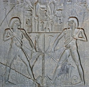 Egyptisk antikvitet: detalj av basen til statuen av farao Ramses II (1292-1186 f.Kr.) som representerer foreningen av Øvre og Nedre Egypt. Tempel i Luxor. Østbredden (Theben), Egypt av Egyptian 19th Dynasty