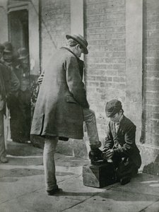 En ung skosvart som skinner med sine sko på gaten av English Photographer