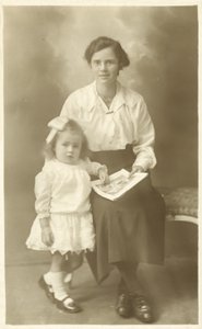Pen jente, mor eller guvernante, viser bilder til små barn (s/hvitt-bilde) av English Photographer