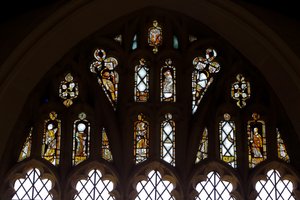 Window Ew som viser tracery-lysene med Gud, Treenigheten, St. Peter. St Paul, St Catherine og Gabriel: og en fugl av English School