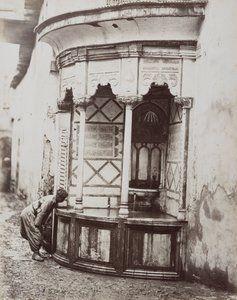 En mann som drikker fra en hjørnefontene, på en gate i Damaskus, Syria av Félix Bonfils