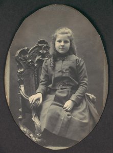 [Jente med ringer, sittende, trekvarts lengde], 1890-tallet.