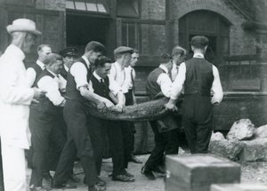 Et team av menn bærer en Alligator overvåket av Sir Peter Chalmers Mitchell, London Zoo, 1924 av Frederick William Bond
