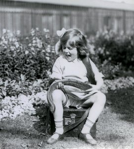 En ung jente Betty som holder en Eastern Indigo Snake mens hun sitter på en skinnkoffert, London Zoo, 1924 av Frederick William Bond
