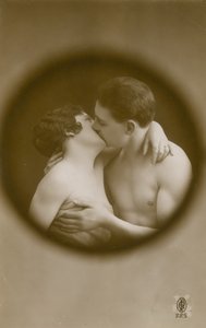 Postkort av en ung mann og kvinne som kysser sett gjennom et kikkhull, sendt i 1913