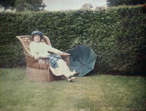 Kvinne sitter i en hagestol (autokrom) av George Bernard Shaw
