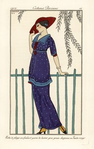 Kvinne i strandkjole av foulard dekorert med store prikker, rød semsket skinnhatt. Robe de plage en foulard garni de tussor gros grain, chapeau en semsket rouge. Håndfarget pochoir (stensil) etsning etter en illustrasjon av George Barbier fra Tommaso Anton av Georges Barbier