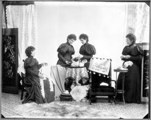 Multieksponering av Hannah Maynard - to som drikker te, en holder et nøste med bomull, en tar den opp til en ball, ca. 1895 (bw-bilde)
