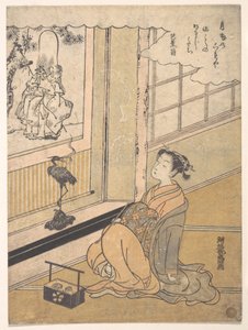 En ung kvinne som sitter i et rom og ser på et kakemono med Fukurokujin av Isoda Koryusai