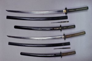 Topp: en katana, japansk sverd og slire, wakizashi, japansk kort sverd i slire, liten Kokatawa-dolk oppbevart i samme slire. alle tre er fra 1700-tallet. de nederste er fra 1600-tallet. av Japanese School