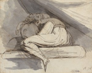 Kvinne sitter, krøllet sammen