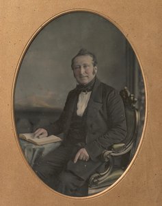 Sittende mann som peker på en passasje i en åpen bok, 1850-tallet.