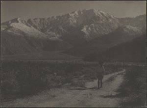 [Kvinne som går på sti mot fjell] av Louis Fleckenstein