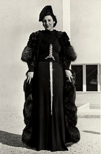 Modell i kveldskjole skapt av det italienske couturehuset "Dragoni". Skriften på artikkelen har en prangende paljettdekor i form av et sverd. En lue og pelsfrakk fullfører ensemblet. (s/hvitt bilde)