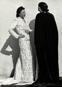 To modeller presenterer kreasjoner av det italienske couture-huset "Dragoni". En modell har på seg et antrekk i bleiemateriale som består av en jakke og et langt skjørt med tog. Den andre modellen, sett bakfra, bærer en lang fløyelsmantel. (s/hvi av Luis Bogino