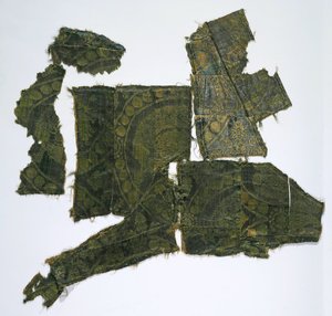 Fragmenter av en kaftan dekket med et silkestoff med et Senmurv-mønster. Moshchevaya Balka-begravelse M av Medieval Culture of the North Caucasian