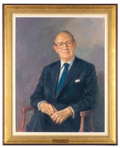 Portrett av Lord Aldington, sittende iført mørk dress