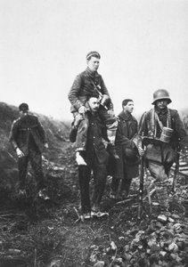 En tysk infanterisoldat med et såret ben blir båret fra kamp av engelske krigsfanger (s/hv-bilde) av Photographer German