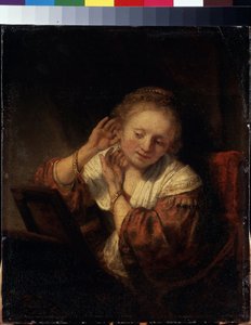 Ung kvinne prøver på øredobber. Ung kvinne prøver øredobber. Maleri av Harmenszoon van Rijn kjent som Rembrandt (1606-1669) av Rembrandt Harmensz. van Rijn