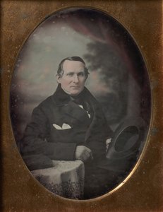 Mann med frakk og hansker, holder hatt, sittende foran malt utendørs bakteppe, 1840-tallet. av Samuel Broadbent Jr..