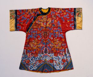 En semi-formell kappe av rød sateng brodert i silke og forgylt tråd med drager blant rullende skyer over en turbulent havbølgekant (sateng, silke) av School Chinese