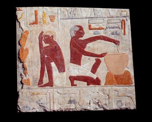 Gammel egyptisk kunst: å bake brød. En mann lager kakepasta, en annen overvåker bakingen av brødformer. Kalkstein (2500-2350 f.Kr.) 5. dynasti. Paris, Musée du Louvre