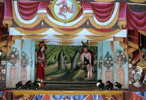 Puppi Theatre i Palermo. Disse dukkene, som tilhører en siciliansk tradisjon som dateres tilbake til antikken, har som mål å fortelle historien om invasjoner og normanniske erobringer. På den øvre delen av fotografiet er det sicilianske symbolet på Trinacr