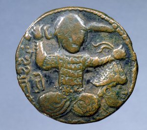 Forside av mynt (bronse) som viser tyrker med hjelm som sitter i kors og holder et sverd bak hodet i høyre hånd og et avkuttet hode med hjelm i venstre hånd. preget av Husam al-Din Yuluq Arslan (1184-1201)