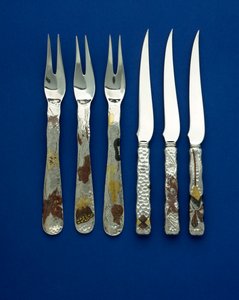 En del av et fint og sjeldent sett med 36 dessertkniver og -gafler, spothamrede håndtak innlagt med patinert kobber og varifarget gull, med graverte detaljer av forskjellige blomster-, dyre- og geometriske design, ca. 1880 (kobber, gull)