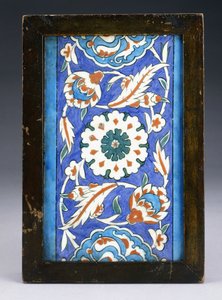 En Iznik-kantflis, med et sentralt blomsterhode mellom rullende palmett og løvranke, ca. 1570 (keramikk) av Turkish School