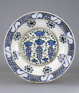 En Iznik keramikkfat, med en sentral runddel som viser tre klaser med druer og vinblader, ca. 1570 (keramikk) av Turkish School