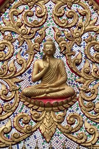 20151102, Vang Vieng, Laos : Inngangsdør dekorert med gullrelieffer. The Teaching Buddha skildrer et spesielt øyeblikk i Buddhas liv, nemlig den første prekenen Buddha holdt etter å ha nådd opplysningstiden av Unbekannt